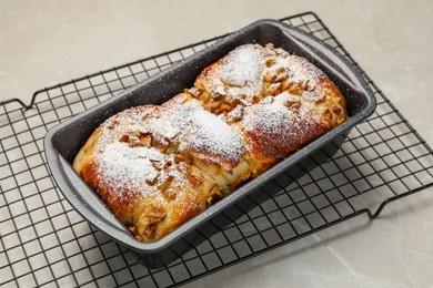 Photo of Delicious yeast dough cake in baking pan on marble table