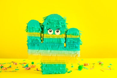Cactus shaped pinata and decor on yellow background