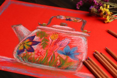 Colorful pastel pencils, flowers and beautiful painting of kettle on table