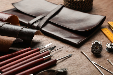 Leather samples and tools on brown table, closeup