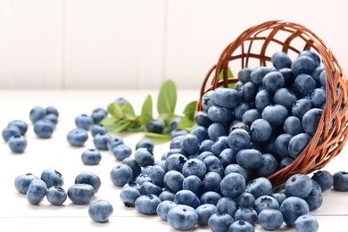 Tasty fresh blueberries on white wooden table, closeup