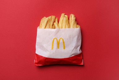 MYKOLAIV, UKRAINE - AUGUST 12, 2021: Small portion of McDonald's French fries on red background, top view