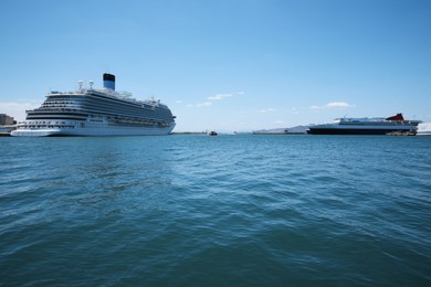 Modern cruise ship and ferry in sea port on sunny day