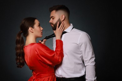 Handsome bearded man with sexy lady on dark background