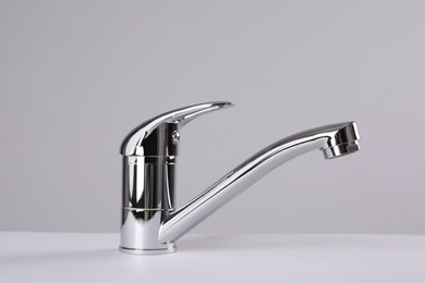 Photo of Single handle water tap on grey background