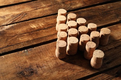 Photo of Christmas tree made of wine corks on wooden table. Space for text