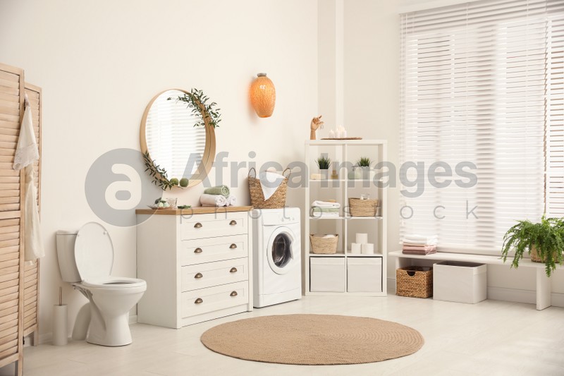 Photo of Interior of stylish bathroom with washing machine