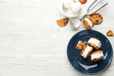 Sweet delicious ice cream cookie sandwiches served on white wooden table, flat lay. Space for text