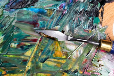 Abstract colorful acrylic paint and spatula, top view
