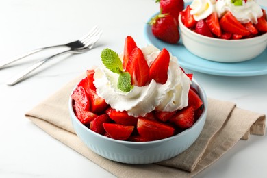 Delicious strawberries with whipped cream served on white table