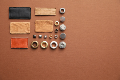 Flat lay composition with garment accessories for jeans on brown background. Space for text