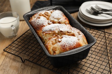 Photo of Delicious yeast dough cake in baking pan on wooden table