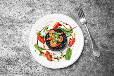 Photo of Delicious black risotto with seafood on grey table, flat lay