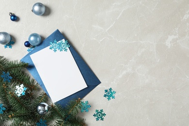 Flat lay composition with blank greeting card and Christmas decor on grey marble table, space for text