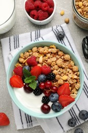 Photo of Flat lay composition with tasty granola and berries on light grey table. Healthy meal