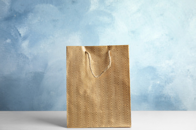 Gold shopping paper bag on white table