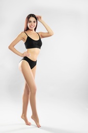 Full length portrait of attractive young woman with slim body in swimwear on white background. Space for text