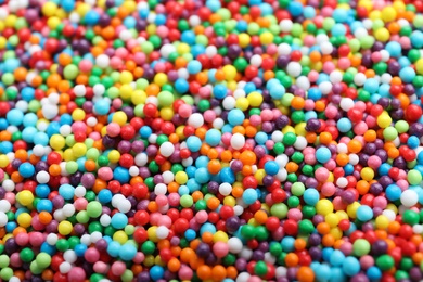 Bright colorful sprinkles as background, closeup. Confectionery decor