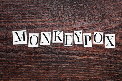 Word Monkeypox made of paper letters on wooden table, top view