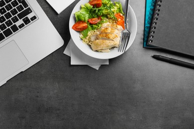 Photo of Bowl of tasty food, laptop and notebooks on grey table, flat lay with space for text. Business lunch