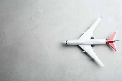 Photo of Toy airplane on grey stone background, top view. Space for text