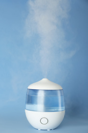 Modern air humidifier on light blue background
