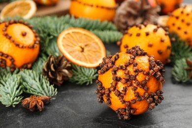 Pomander balls made of fresh tangerines with cloves  on dark table, closeup. Christmas atmosphere