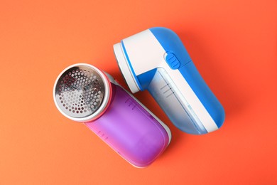 Photo of Different fabric shavers on orange background, top view