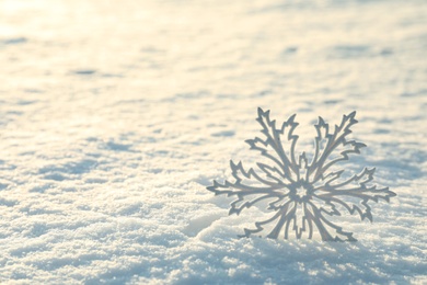 Beautiful decorative snowflake in white snow, outdoors. Space for text