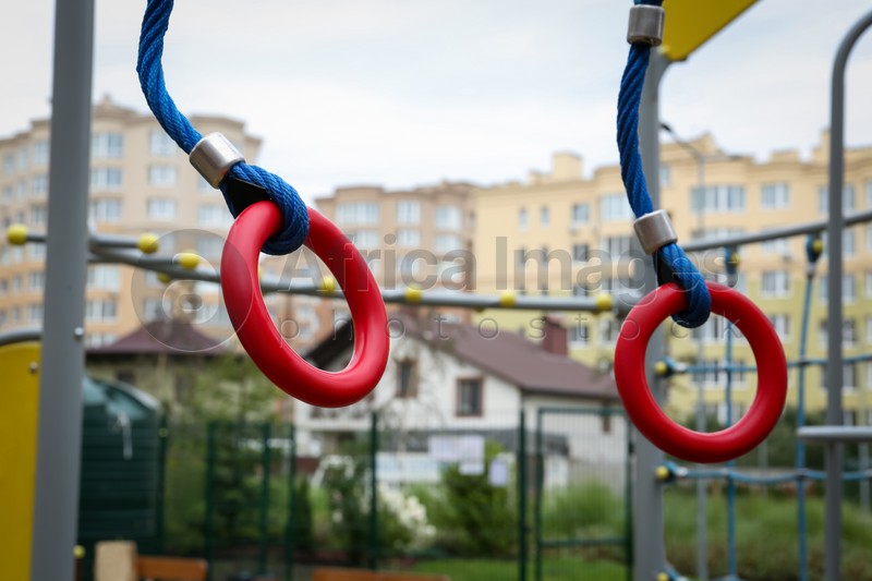 Photo of Gymnastic rings on outdoor playground in residential area