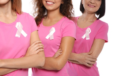 Photo of Group of women with silk ribbons on white background, closeup. Breast cancer awareness concept