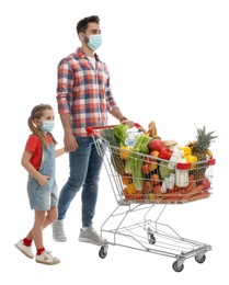 Father and daughter in medical masks with shopping cart full of groceries on white background