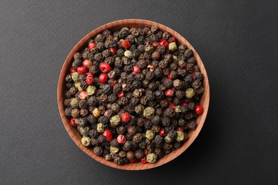 Bowl with peppercorn mix on grey background, top view