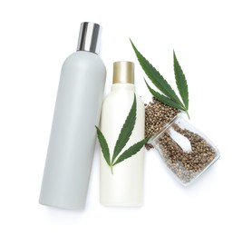 Set of hemp cosmetics with green leaves and seeds isolated on white, top view