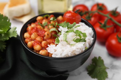 Delicious chickpea curry with rice in bowl on table, closeup