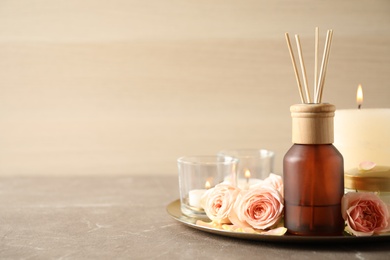 Photo of Spa composition with aroma oil and roses on grey table, space for text
