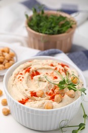 Delicious hummus with chickpeas and paprika served on white table, closeup