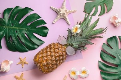 Flat lay composition with pineapple, sunglasses and beach items on color background. Creative concept