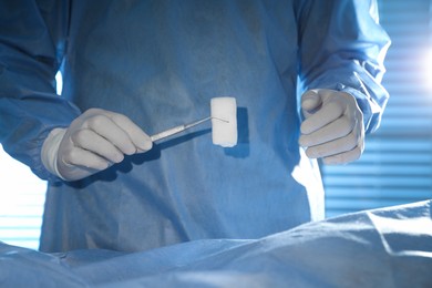 Photo of Professional surgeon with instruments performing operation in clinic, closeup
