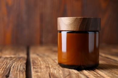 Jar of luxury cream on wooden table, closeup. Space for text
