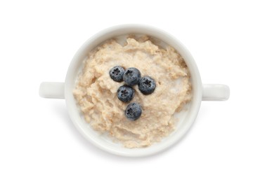 Tasty oatmeal porridge with blueberries in bowl on white background, top view