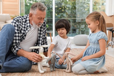 Photo of Grandfather playing with his grandchildren at home