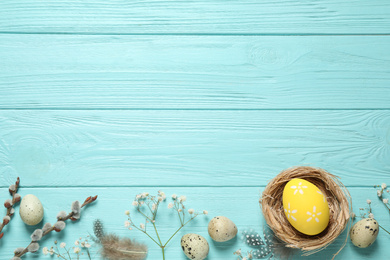Flat lay composition with Easter eggs on light blue wooden background. Space for text