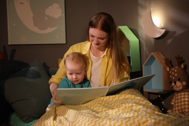 Photo of Mother and child reading book in room with crescent shaped night lamp