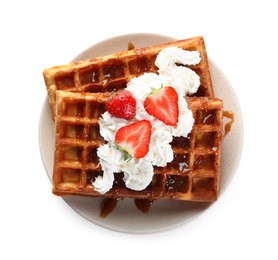 Photo of Delicious Belgian waffles with strawberries, whipped cream and caramel sauce on white background, top view
