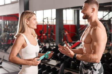 Photo of Trainer having discussion with woman in gym