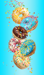 Image of Set of falling delicious donuts on light blue background