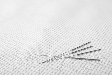 Acupuncture needles on towel, closeup. Alternative medicine