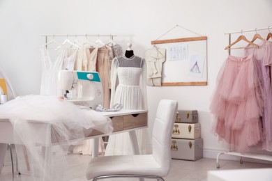 Dressmaking workshop interior with wedding dresses, female clothes and equipment