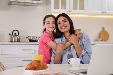 Portrait of happy mother and daughter together in kitchen. Single parenting